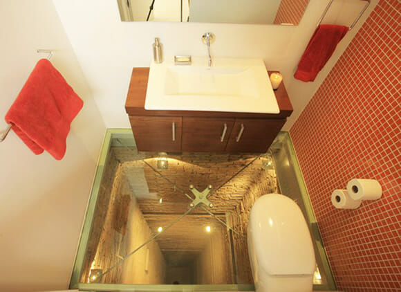 Banheiro construído em cima de um poço e com chão de vidro. Vai encarar?