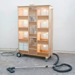 Artista transforma aspiradores de pó em miniaturas de casas que sugam a sujeira para seu interior